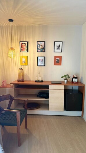 A modern kitchen with a built-in refrigerator, a coffee machine, and a dining area with a chair and table. - La Casa de los Pintores / Av Federalismo / 6 Reca (Guadalajara)