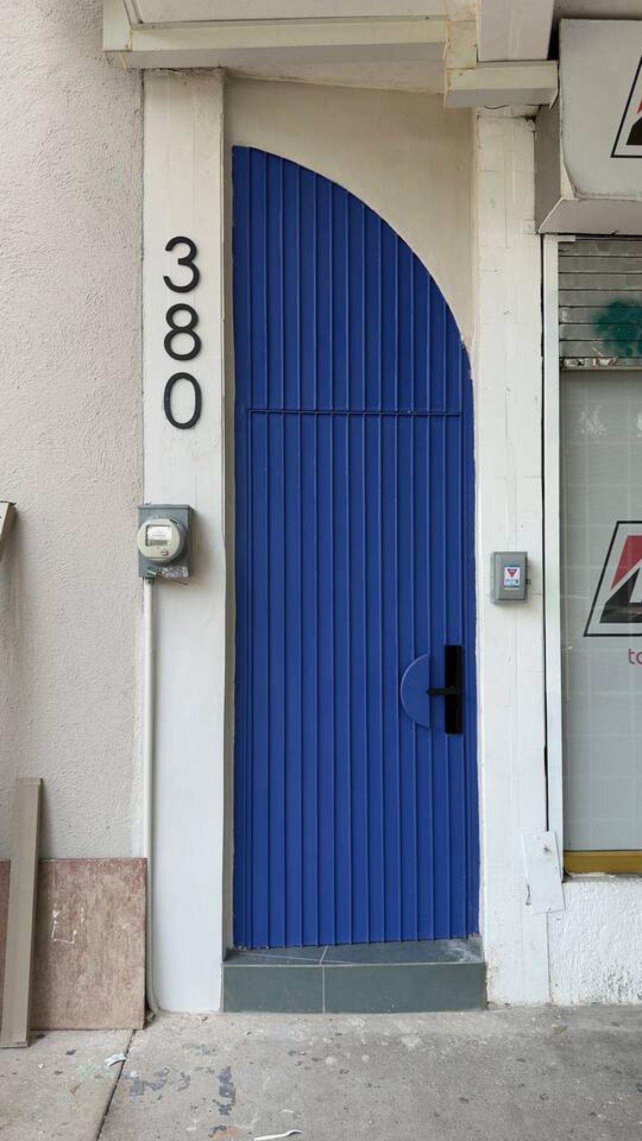 A blue door with the number 380 on the wall beside it.