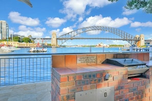 Un espace barbecue extérieur avec vue sur le pont du port de Sydney.