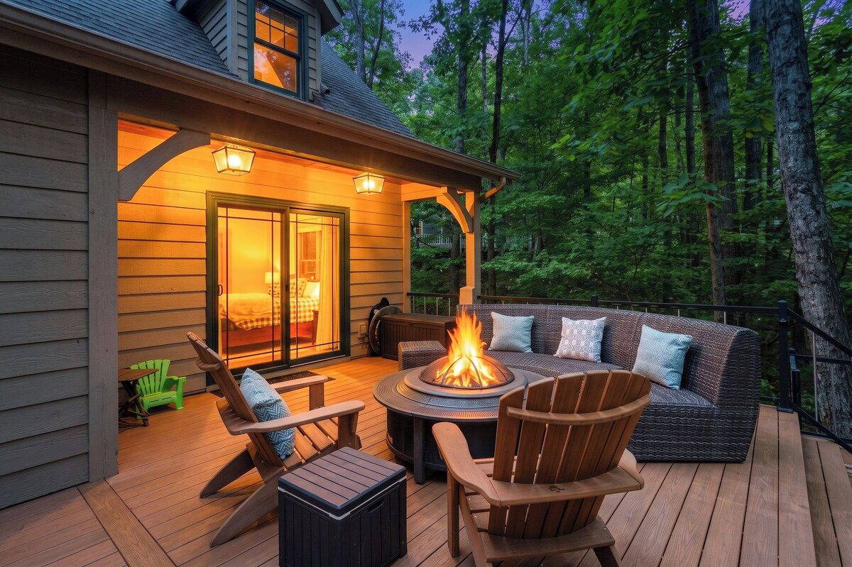 Una terraza con mobiliario exterior, una chimenea y la entrada de un edificio.