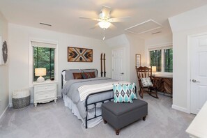 A bedroom with a bed, bedside table, lamp, chair, and a ceiling fan. - Wintergreen Resort, Hot Tub, Trails, and Ski! (Nellysford)