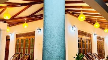 A lobby with a high ceiling, wooden beams, and hanging light fixtures.