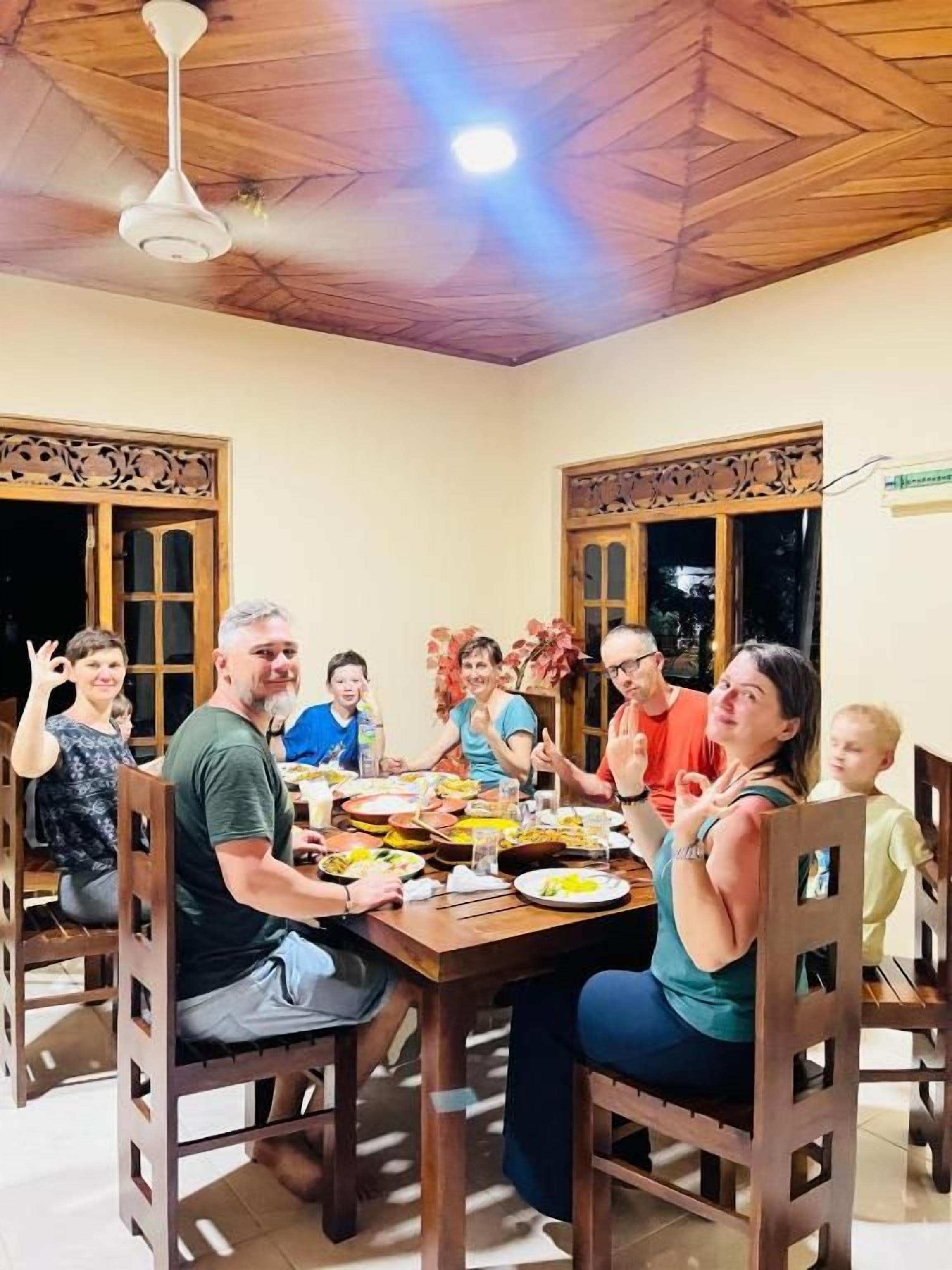 Ein Esszimmer mit Holzboden, einer Chandelierleuchtre und einem für eine Mahlzeit gedeckten Esstisch.