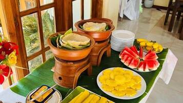 A buffet table with various food items including bread, fruits, and condiments.