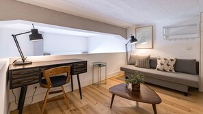 A modern living room with a desk, chair, sofa, and coffee table. - Design 2BR Duplex with AC by LovelyStay (Lisboa)