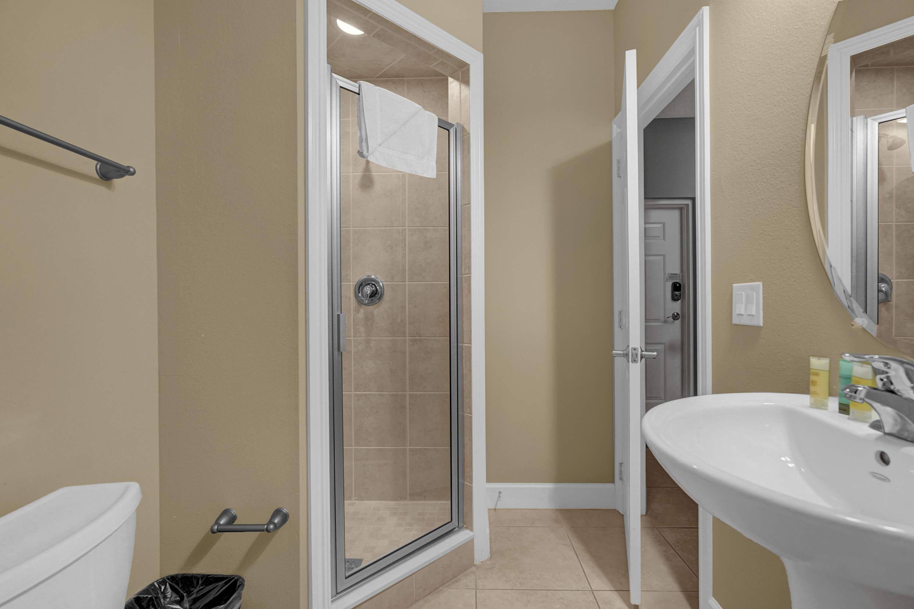 A bathroom with a shower, toilet, and sink.