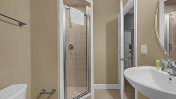 A bathroom with a shower, toilet, and sink.