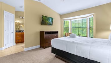 A bedroom with a large bed, a dresser, a painting, and a window with blinds.