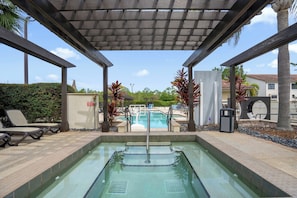 A pool area with a pergola overhead, lounge chairs, and a view of the pool. - Spacious Resort Home Near Disney - Pool, Hot Tub (Orlando)