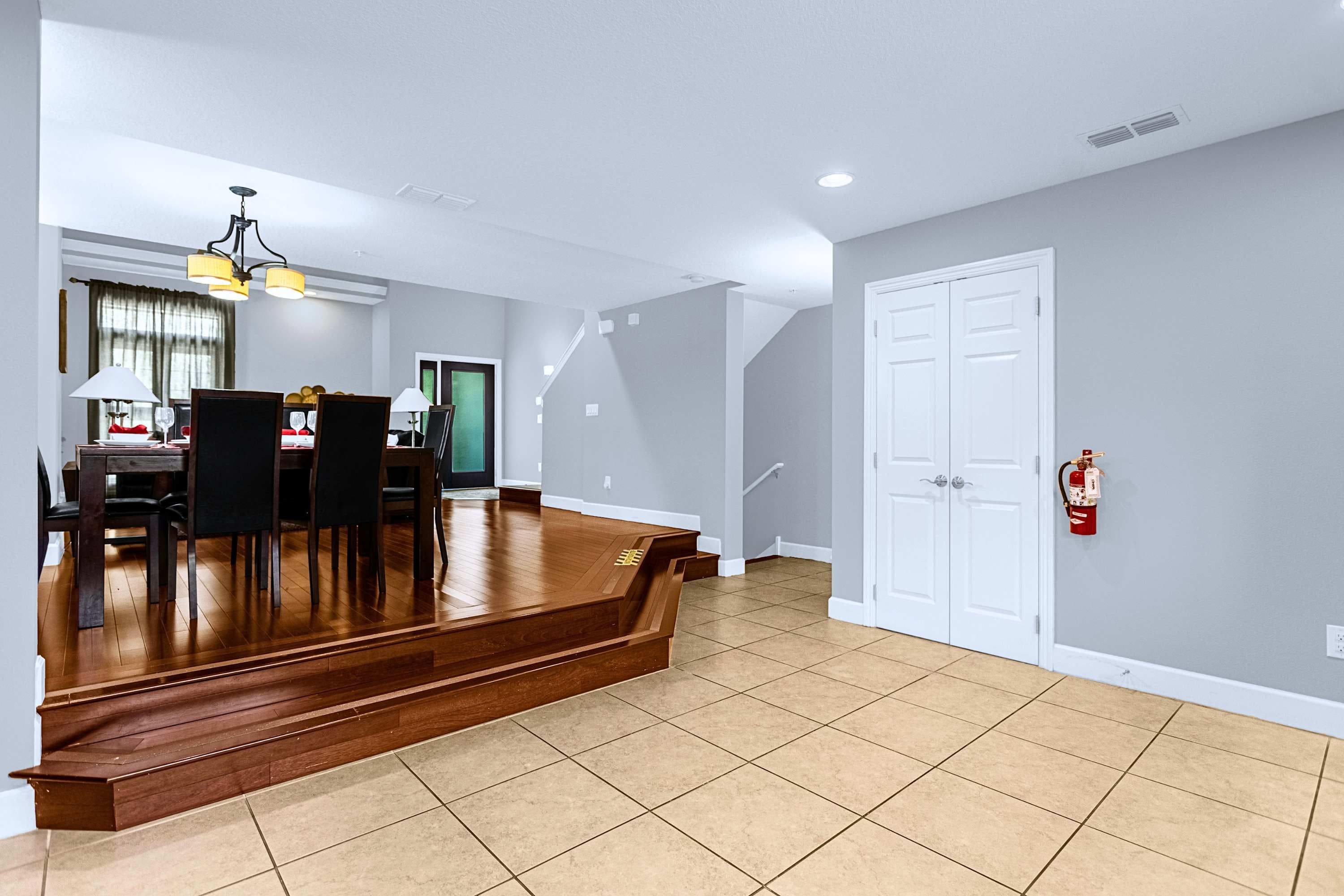 A spacious interior with a dining area, a staircase, and a fire extinguisher on the wall.