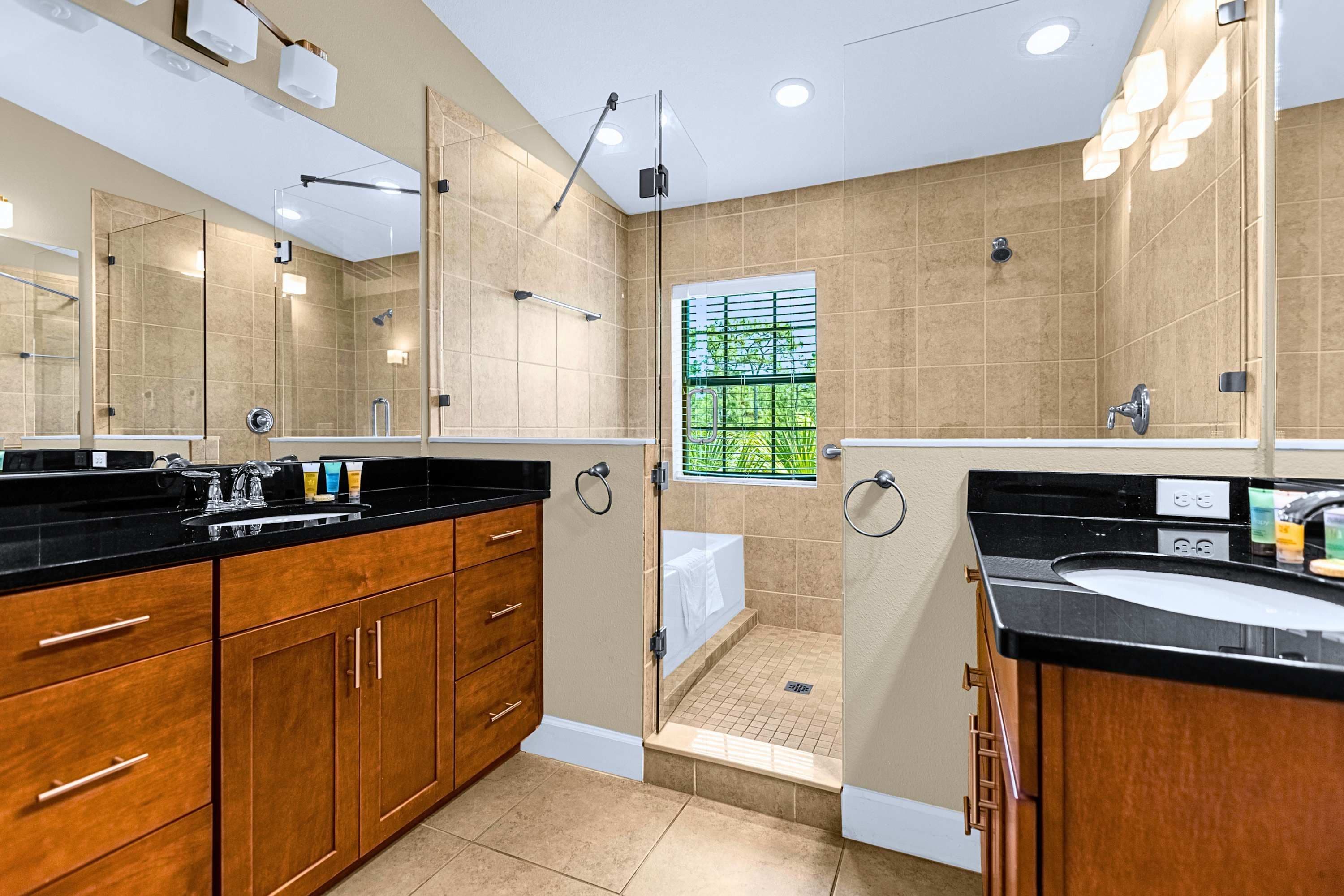 A modern bathroom with a walk-in shower, a bathtub, and a vanity with a sink.