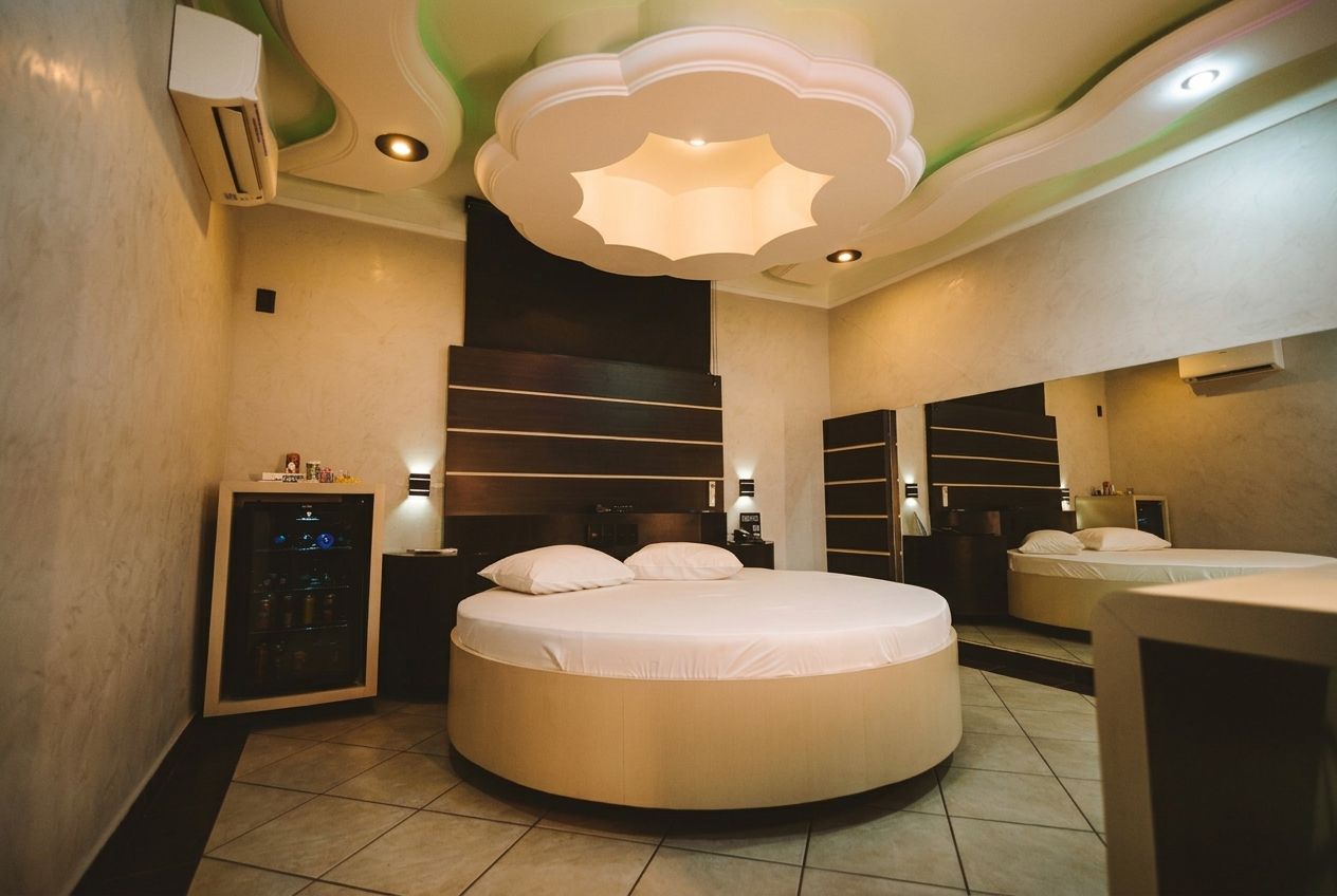 Un dormitorio moderno con una cama redonda, armario empotrado y un diseño de techo original.