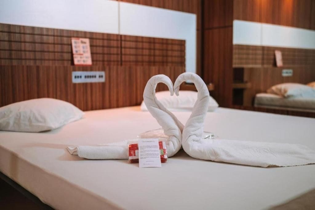 Una habitación de hotel con una cama bien hecha, un cabecero de madera y un cartel en la pared.
