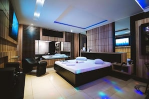 Une chambre moderne avec un grand lit, un bureau et un téléviseur.