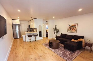 Ein modernes Apartment mit Küche, Essbereich und Wohnzimmer.