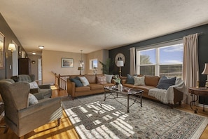 A living room with a sofa set, a coffee table, and a patterned rug.