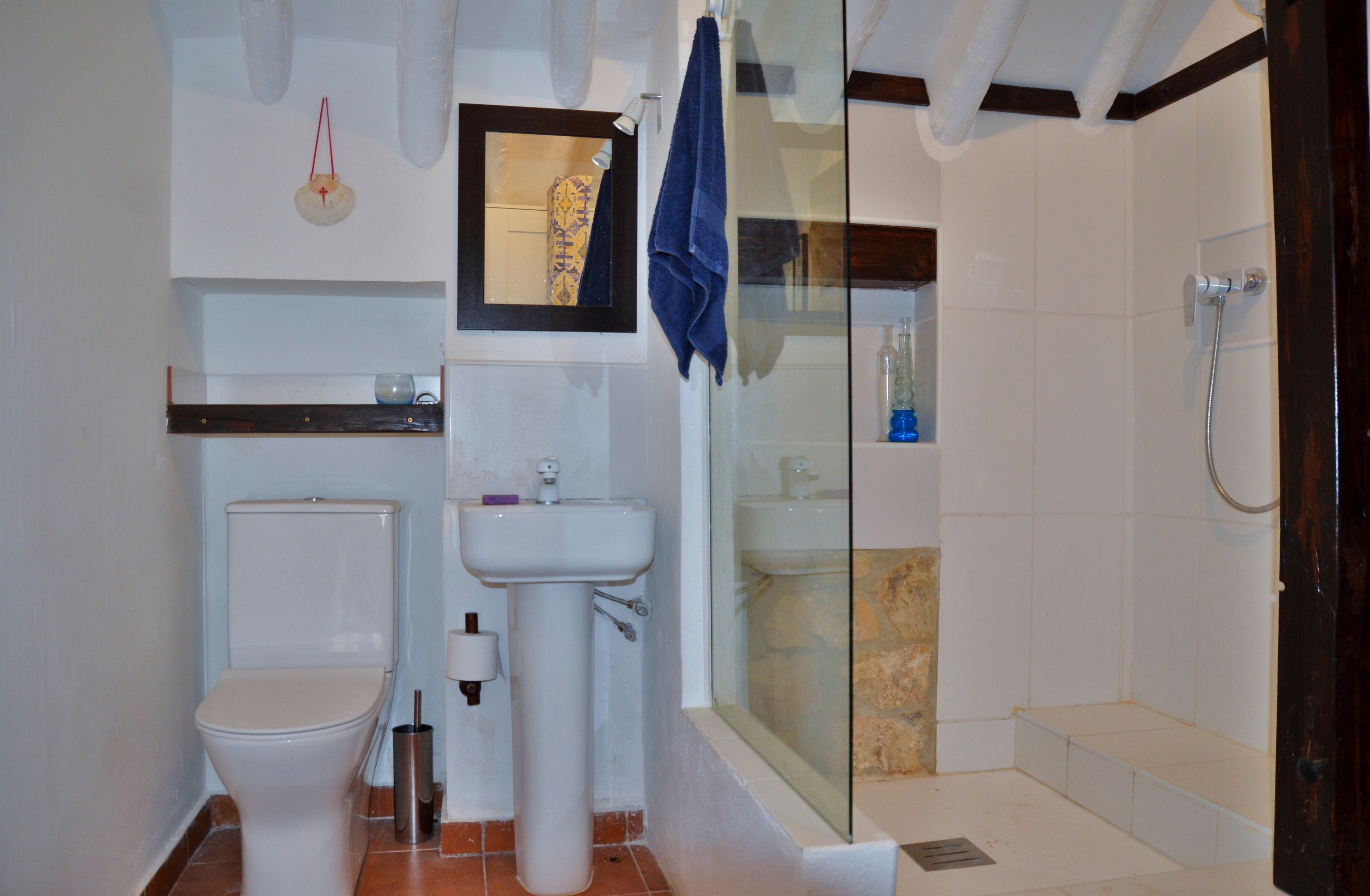 Une salle de bain comprenant des toilettes, un lavabo et un espace douche.