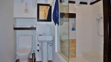 Une salle de bain comprenant des toilettes, un lavabo et un espace douche.