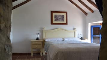 Un dormitorio con cama, mesitas de noche, un cuadro en la pared y una ventana con vistas.