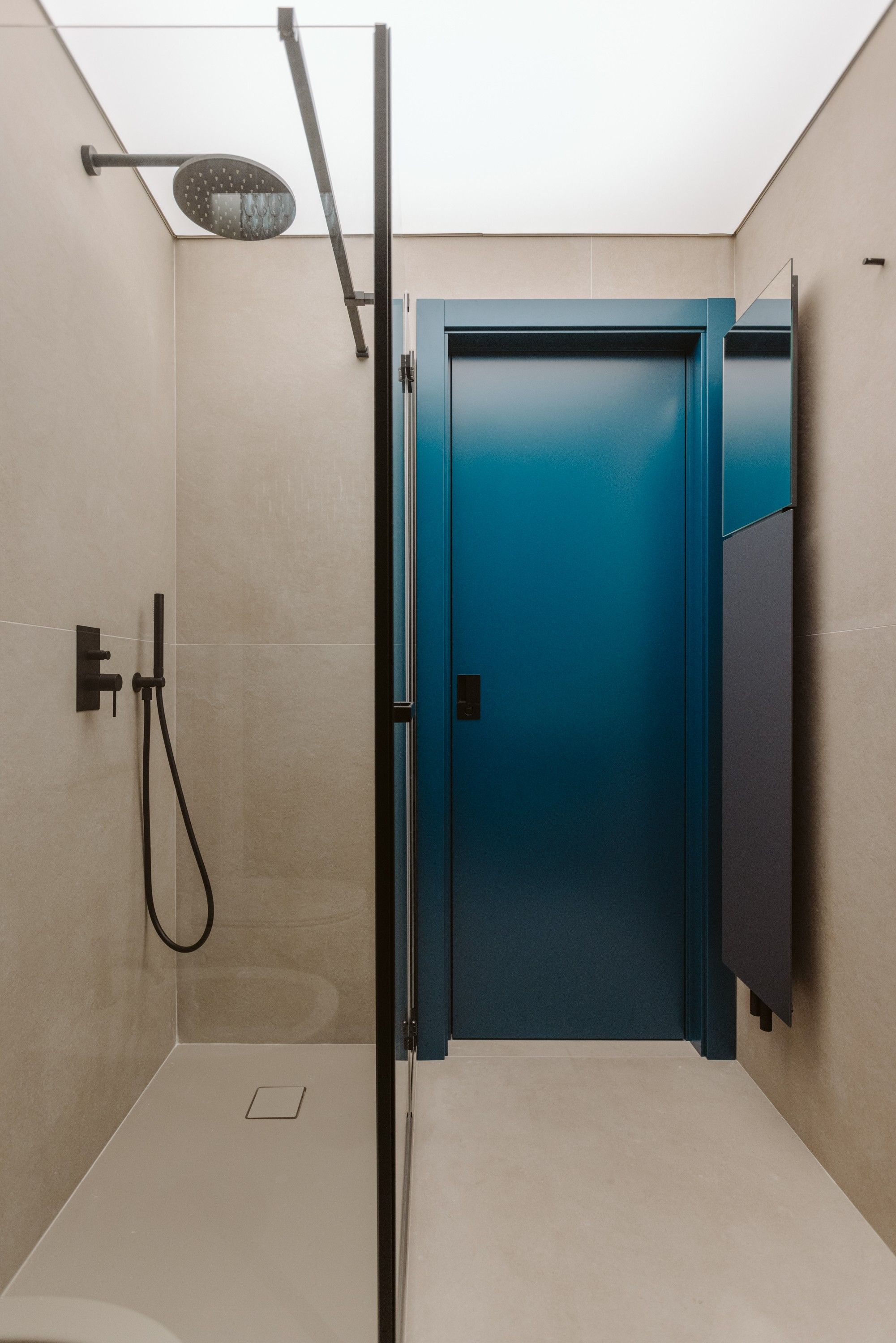 Une salle de bain moderne équipée d’une douche, d’une porte et d’un porte-serviettes.