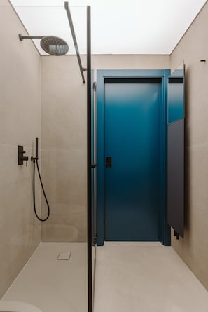 Une salle de bain moderne équipée d’une douche, d’une porte et d’un porte-serviettes.