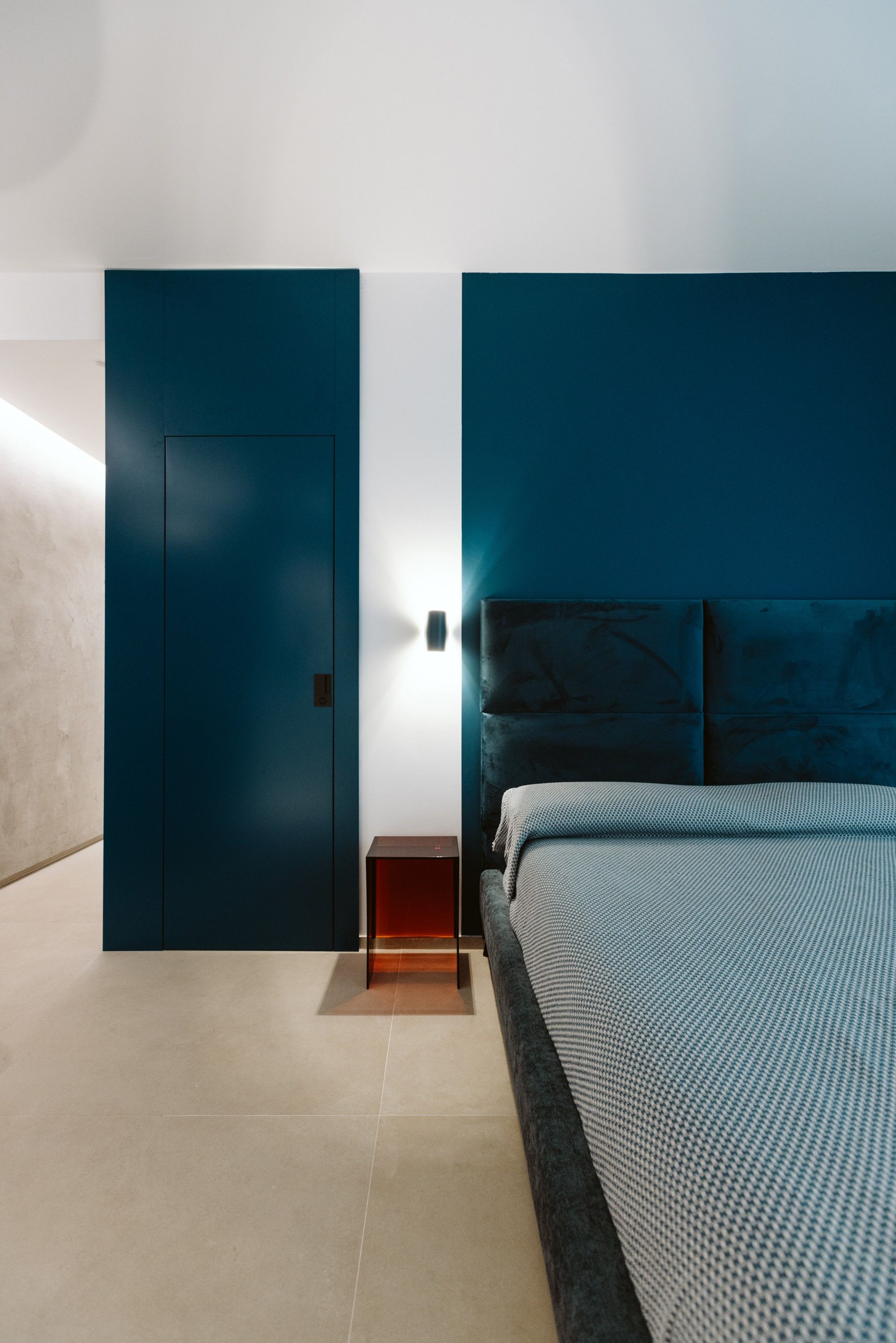 Une chambre à coucher moderne avec un lit, une table de chevet et une armoire.