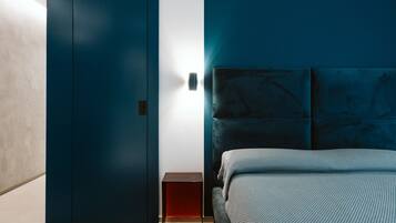 Une chambre à coucher moderne avec un lit, une table de chevet et une armoire.