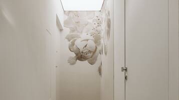 Un couloir étroit avec une lucarne et une peinture murale.
