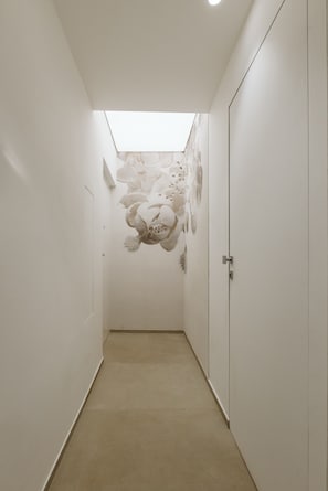 Un couloir étroit avec une lucarne et une peinture murale.