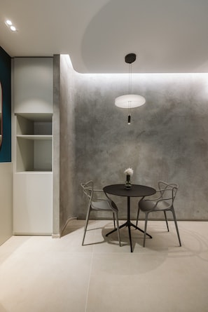 Un intérieur moderne avec une table ronde, deux chaises et un luminaire suspendu.