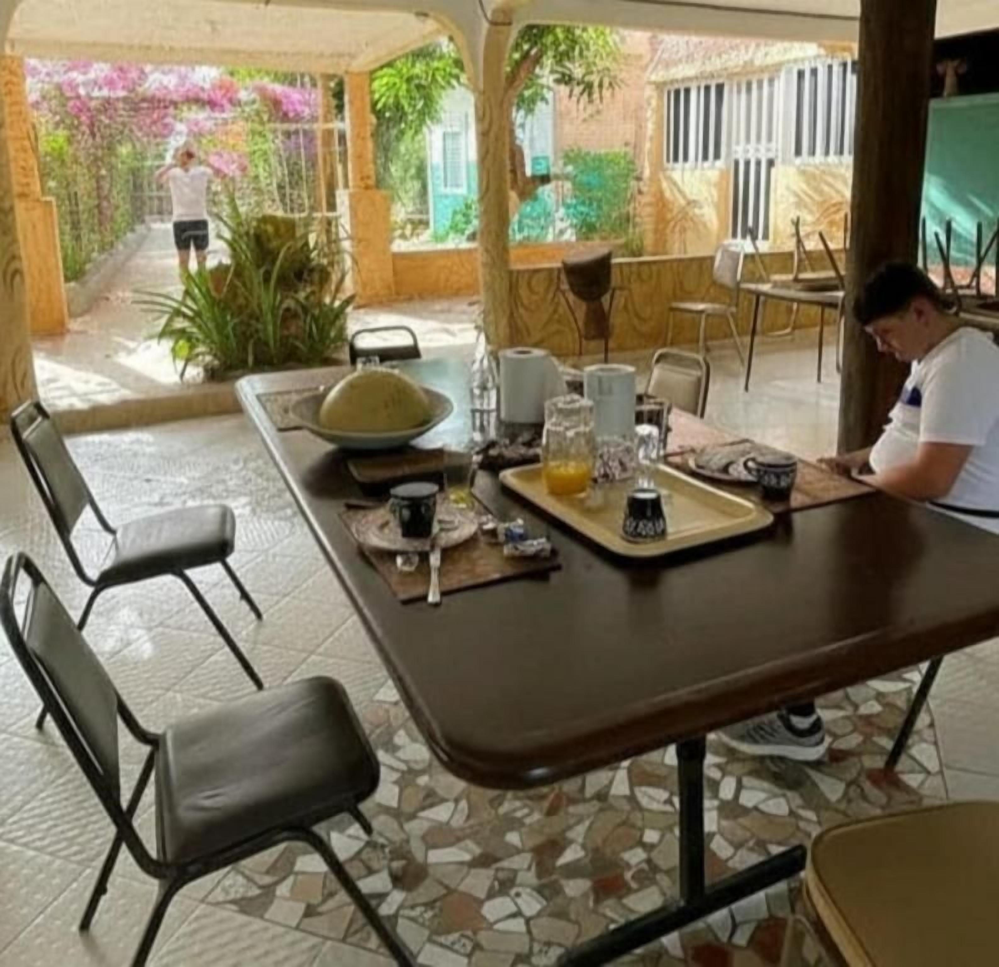 A dining area with a table set for two, including a bowl, glasses, and a bottle.