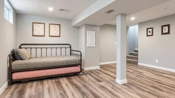 A room with a bed, a door, and a staircase.