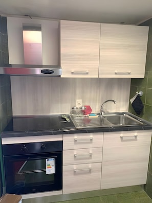 A modern kitchen with a built-in oven, a stainless steel sink, and light-colored cabinetry. - Holiday Home 'Bilocale Con Terrazza E Piscina' with Air Conditioning (Marina di Bibbona)