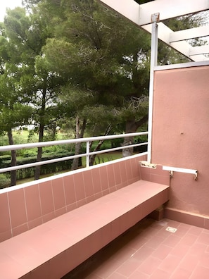 A restroom with a bench, tiled walls, and a view of trees. - Holiday Home 'Bilocale Con Terrazza E Piscina' with Air Conditioning (Marina di Bibbona)