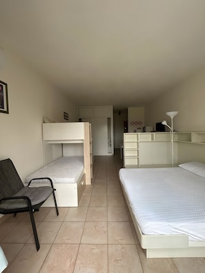 A room with bunk beds, a desk, and a chair. - Holiday Home 'Monolocale Con Terrazza E Piscina' with Wi-Fi and Air Conditioning (Marina di Bibbona)