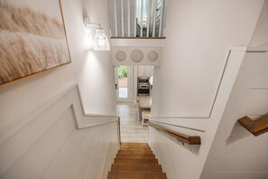 A staircase leading to a kitchen area with a view of the outdoors. - Luxury Stay on 30A- Gym, Bikes & Custom Golf Cart! (Inlet Beach)