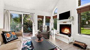 A living room with a fireplace, a sofa, a chair, and a coffee table.