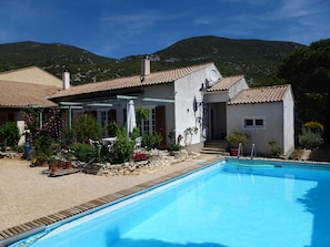 A residential property with a swimming pool, a garden with potted plants, and a view of mountains. - In the heart of the Luberon Nature Park, in Rustrel: a quiet vacation rental perfect for relaxing (Rustrel)