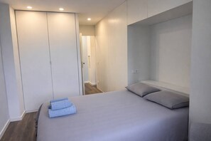 A bedroom with a bed, pillows, a wardrobe, and a headboard. - Downtown Porto. Trindade Metro. (Porto)