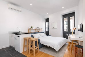 A compact bedroom with a bed, a small kitchenette, a desk, and a chair. - Downtown Riverside Gaia, Porto (Vila Nova de Gaia)