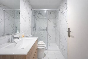 A modern bathroom with a glass-enclosed shower, a white sink, and a toilet. - Downtown Riverside Gaia, Porto (Vila Nova de Gaia)