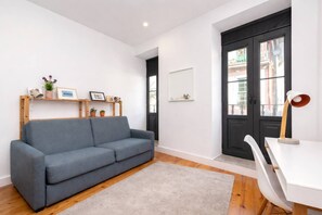 A modern living room with a grey sofa, a white desk, and a black door. - Downtown Riverside Gaia, Porto (Vila Nova de Gaia)