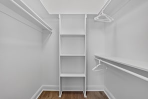 Un armario con estantes blancos y una escalera.