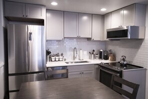 A modern kitchen with stainless steel appliances, a microwave, and a kettle. - Downtown Aspen with Patio, Fireplace, Parking, W/D (Aspen)