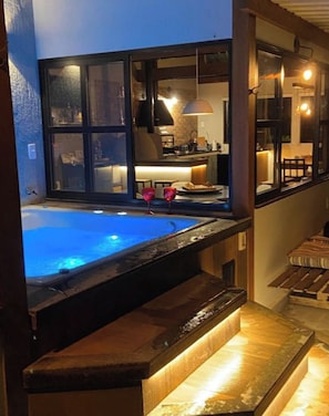 A hot tub area with a view of a kitchen and dining area.