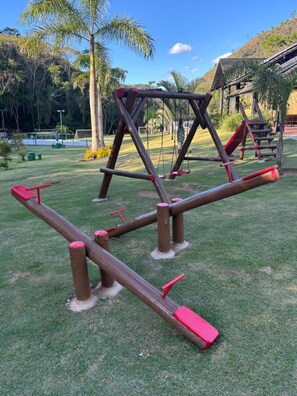 A playground with swings and a seesaw. - Casa Refúgio  (Teresópolis)