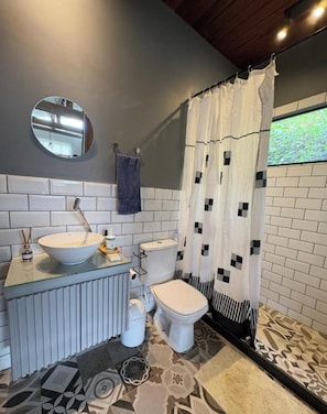 A bathroom with a white sink, toilet, and shower curtain.