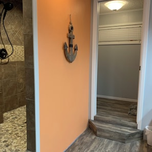 A bathroom with a tiled floor, a shower area, and a wall-mounted towel rack. - Waterfront Spacious 4-bedroom house on Toledo Bend in Hemphill (Hemphill)