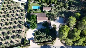 Eine Vogelperspektive auf ein Anwesen mit Schwimmbad, Terrassenbereich und Garten.