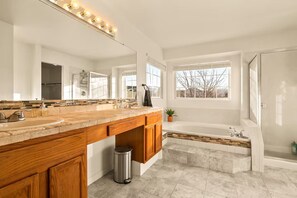 Ein modernes Badezimmer mit einem großen Waschtisch, einer Badewanne und einer Dusche.